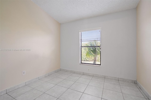 tiled spare room featuring a textured ceiling