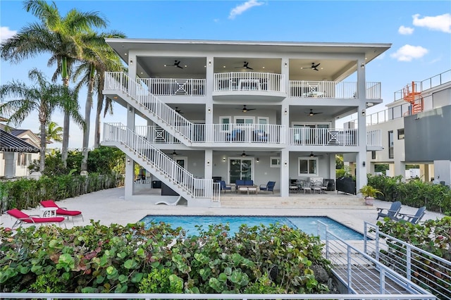 rear view of property with a fenced in pool, a balcony, a patio, and ceiling fan