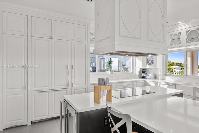 kitchen with white cabinetry, backsplash, wine cooler, black electric stovetop, and custom exhaust hood