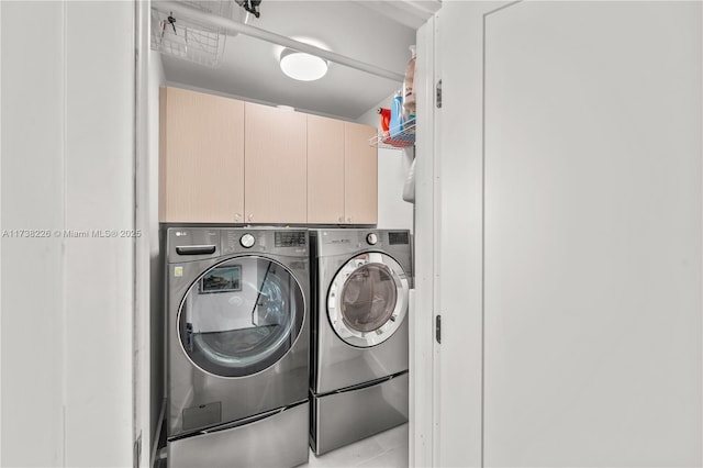 washroom featuring cabinets and washing machine and clothes dryer