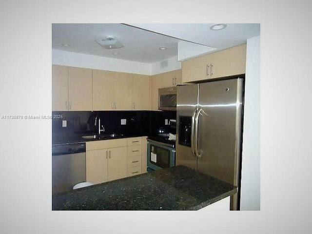 kitchen featuring sink, light brown cabinets, kitchen peninsula, stainless steel appliances, and decorative backsplash