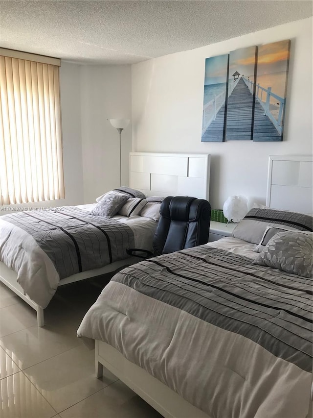 bedroom with tile patterned flooring and a textured ceiling