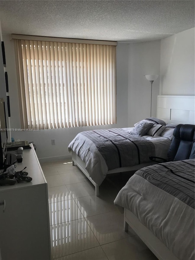 bedroom with light tile patterned floors and a textured ceiling