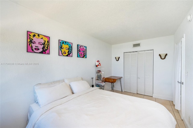 tiled bedroom featuring a textured ceiling and a closet