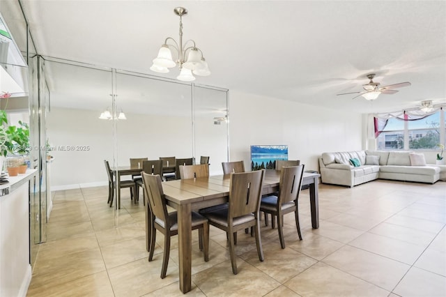 dining space with ceiling fan with notable chandelier and light tile patterned floors