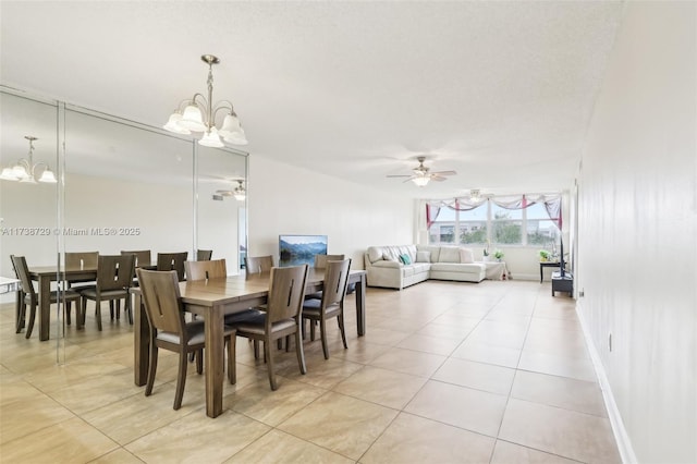 tiled dining area with ceiling fan with notable chandelier