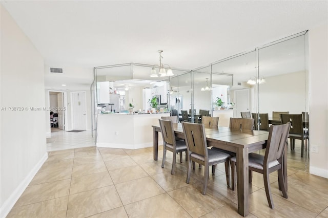 tiled dining space featuring a notable chandelier