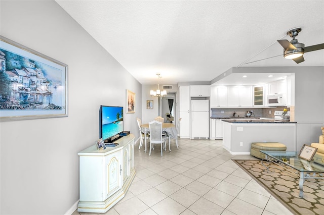 interior space with light tile patterned floors, white appliances, white cabinetry, dark countertops, and glass insert cabinets