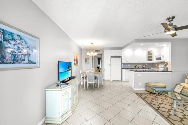 3011 Islewood D 3011, Deerfield Beach, FL 33442 - living area featuring light tile patterned flooring, visible vents, baseboards, and ceiling fan with notable chandelier