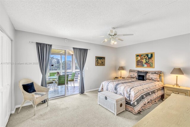 carpeted bedroom with ceiling fan, access to exterior, and a textured ceiling