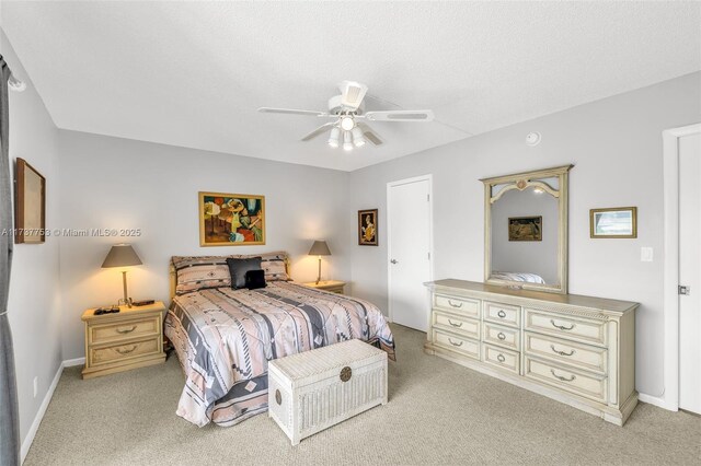 carpeted bedroom featuring a textured ceiling and ceiling fan