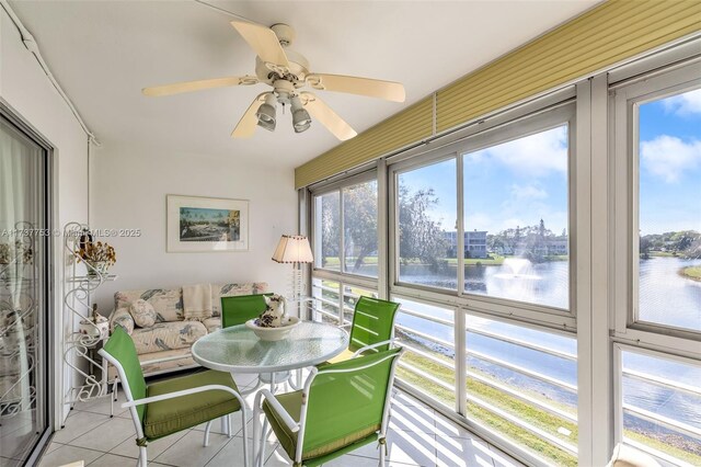 sunroom featuring a water view and ceiling fan