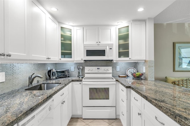 kitchen with white appliances, white cabinets, glass insert cabinets, a sink, and light tile patterned flooring