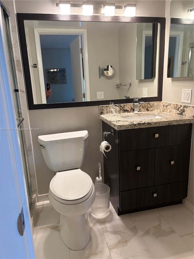 bathroom featuring marble finish floor, vanity, and toilet