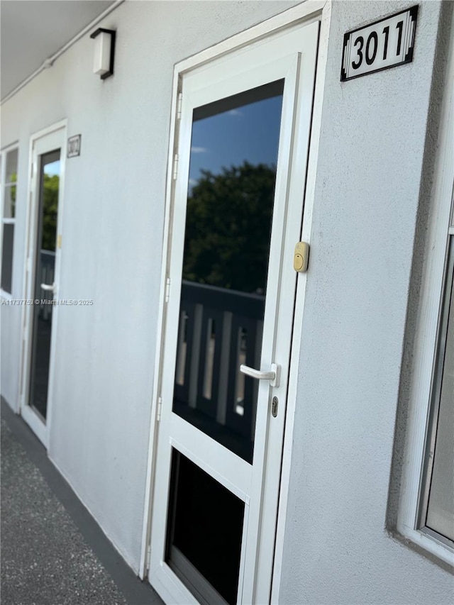 doorway to property featuring stucco siding