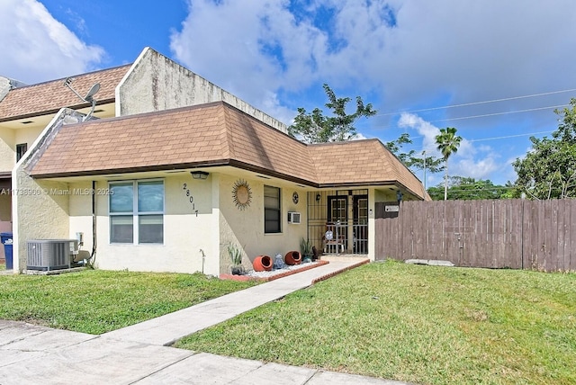 view of front of house featuring central AC unit and a front yard