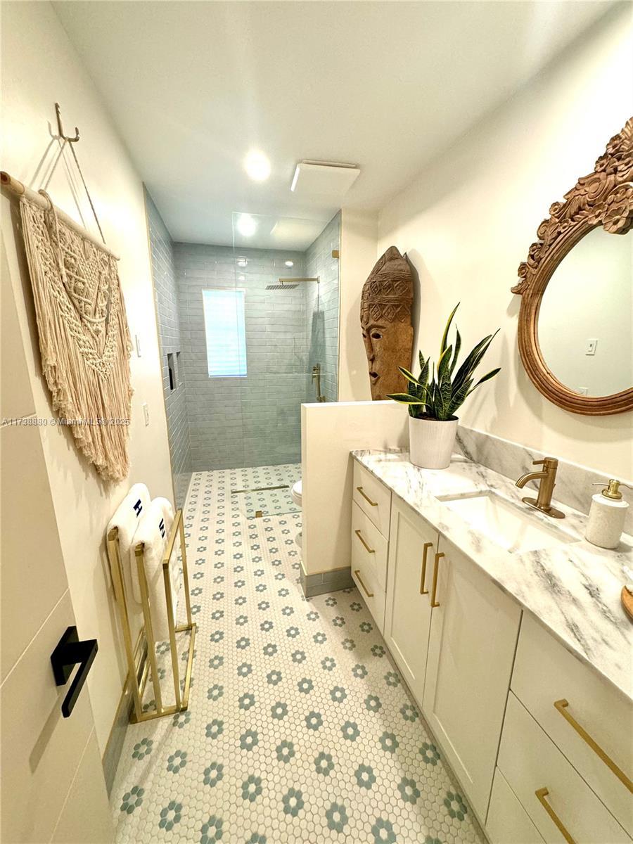 bathroom featuring vanity, a shower with shower door, and toilet