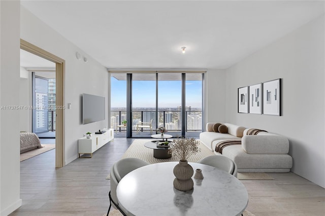 living room with expansive windows and light wood-type flooring