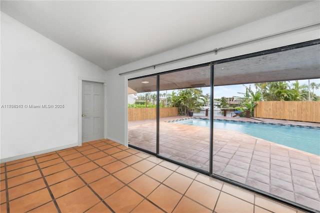 spare room with tile patterned floors and lofted ceiling