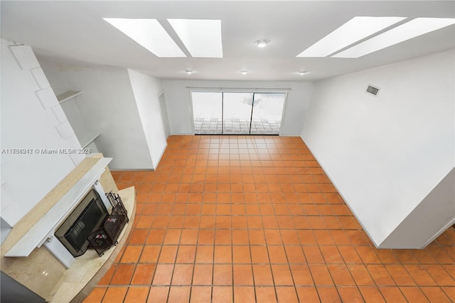 unfurnished living room featuring a skylight