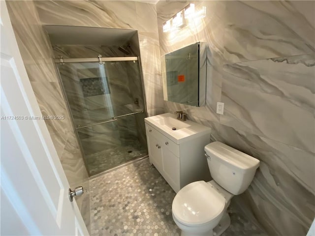 bathroom featuring vanity, toilet, tile walls, and walk in shower