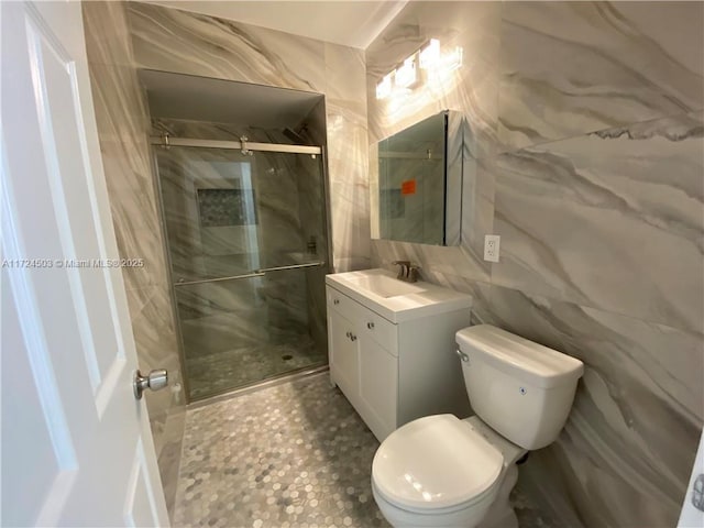 bathroom with tile walls, vanity, toilet, and walk in shower