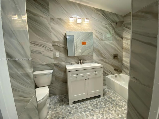 full bathroom featuring vanity, bathtub / shower combination, tile walls, and toilet