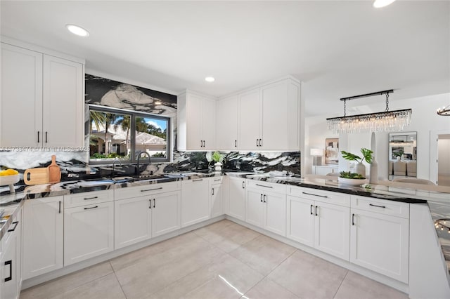 kitchen with white cabinetry, decorative backsplash, and decorative light fixtures