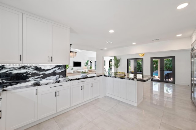 kitchen featuring a peninsula, visible vents, white cabinetry, open floor plan, and french doors