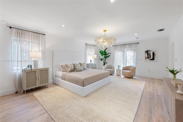 bedroom featuring ornamental molding, baseboards, visible vents, and light wood finished floors