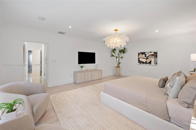 bedroom featuring light wood-style floors, recessed lighting, ornamental molding, and an inviting chandelier