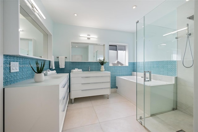 full bathroom featuring tile walls, a soaking tub, a shower stall, vanity, and tile patterned flooring