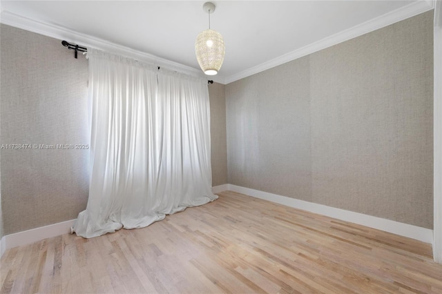 unfurnished room with wallpapered walls, crown molding, baseboards, and wood finished floors