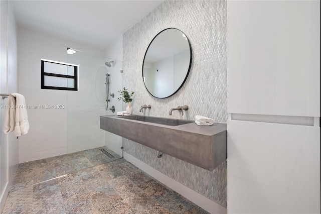 full bathroom featuring a sink, stone finish flooring, a walk in shower, and tile walls