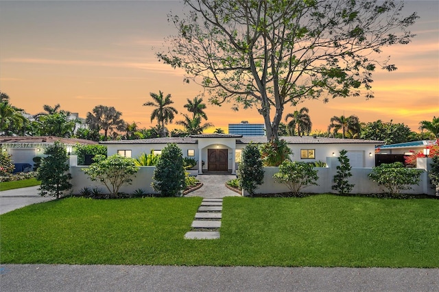 view of front of home with a lawn and stucco siding