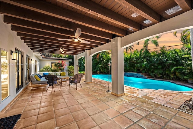 pool at dusk with an outdoor pool, a patio area, and ceiling fan