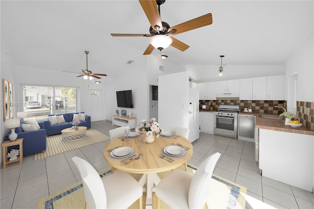 dining area with high vaulted ceiling, sink, and light tile patterned floors