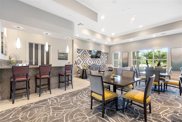 tiled dining area featuring a tray ceiling