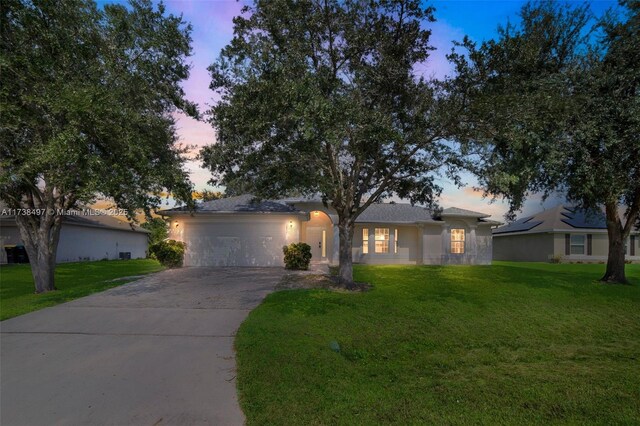 ranch-style house featuring a garage and a front yard