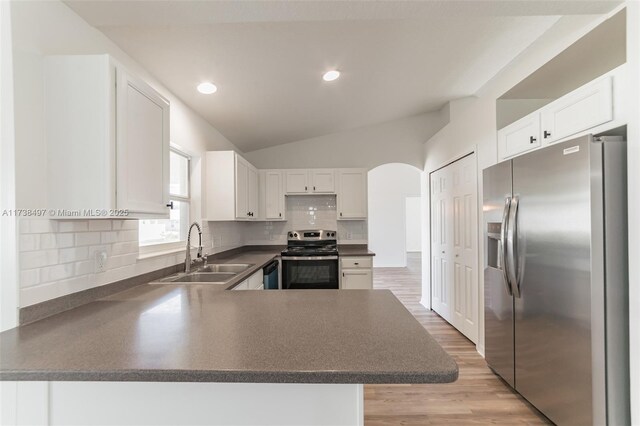 kitchen with stainless steel appliances, sink, white cabinets, and kitchen peninsula