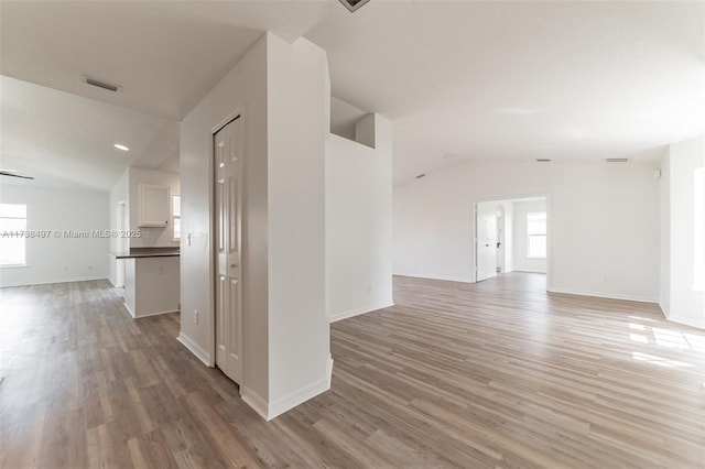 unfurnished room with lofted ceiling and hardwood / wood-style floors