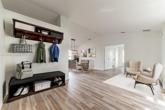 mudroom featuring light wood-style floors, lofted ceiling, and visible vents