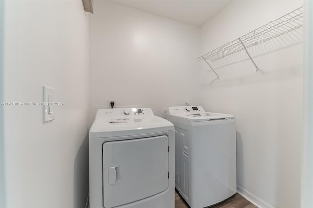 clothes washing area with laundry area, baseboards, and washing machine and clothes dryer