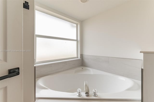 bathroom with a relaxing tiled tub