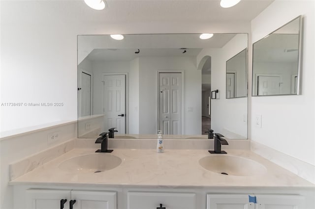 bathroom featuring a sink, double vanity, and a closet