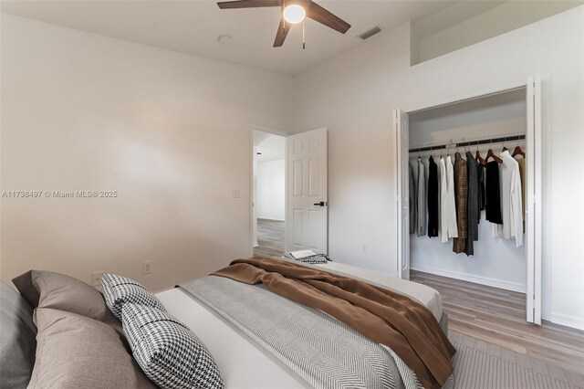 bedroom with hardwood / wood-style flooring, ceiling fan, and a closet