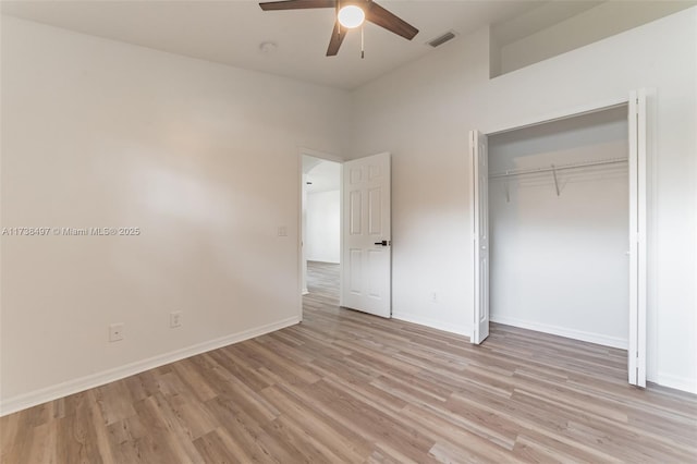 unfurnished bedroom featuring visible vents, baseboards, light wood-style flooring, ceiling fan, and a closet