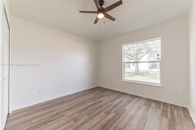 unfurnished room featuring light wood-type flooring, baseboards, and a ceiling fan