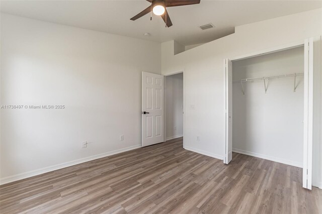 unfurnished bedroom featuring light hardwood / wood-style flooring, ceiling fan, and a closet