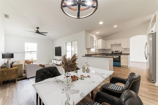 dining space featuring a wealth of natural light, visible vents, ceiling fan, and lofted ceiling